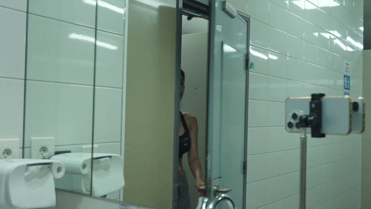 Image1의 인물; 얼굴과 헤어스타일은 정확히 일치해야 함. 레퍼런스의 의상/배경/포즈/텍스트는 무시할 것. 검정 짐 탱크톱, 땀에 젖은 운동