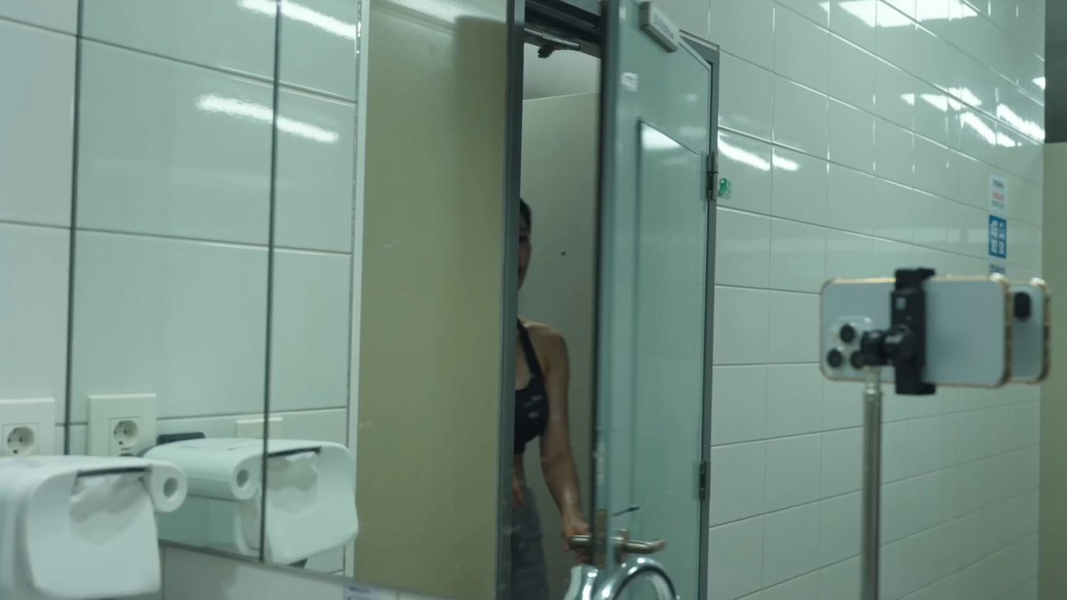 Image1의 인물; 얼굴과 헤어스타일은 정확히 일치해야 함. 레퍼런스의 의상/배경/포즈/텍스트는 무시할 것. 검정 짐 탱크톱, 땀에 젖은 운동